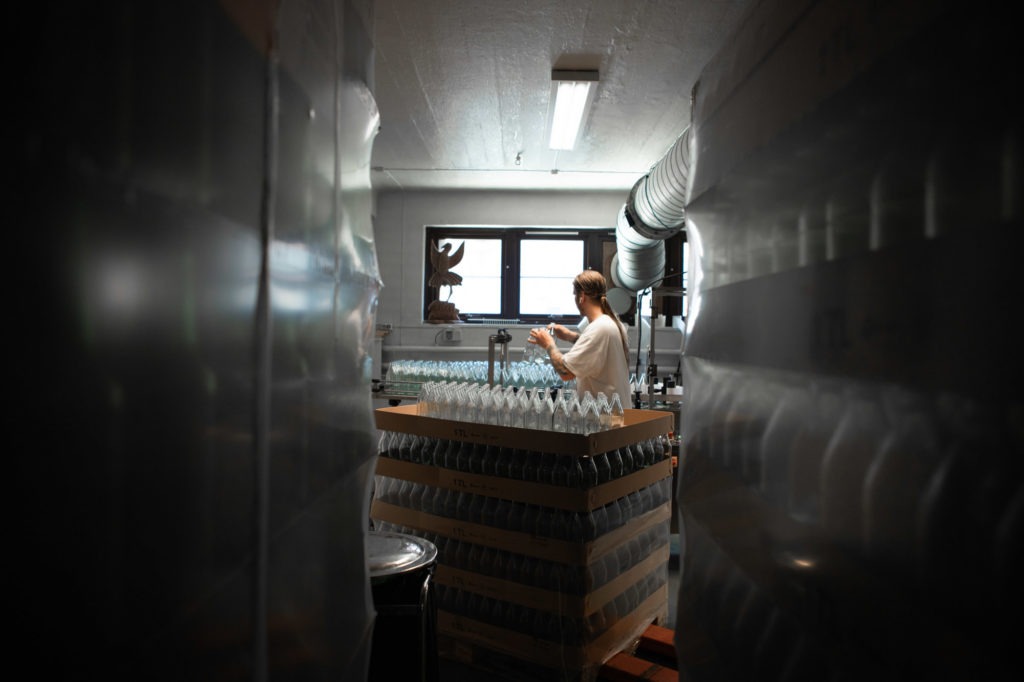 Rikard Svensk, co-founder of tøyencola is stacking new bottles on the tray.